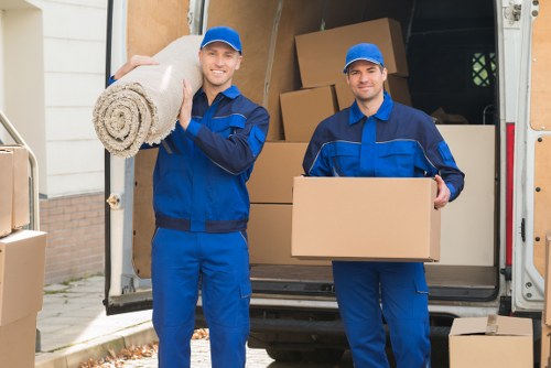 Local movers carrying furniture through a Colindale residential street